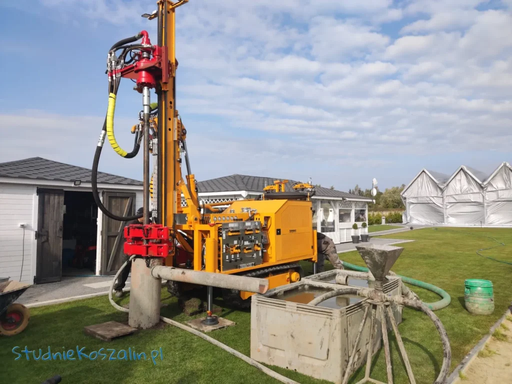 Nowoczesna żółta wiertnica przy domu jednorodzinnym.